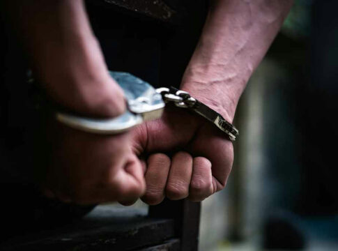 Hands in handcuffs behind back.