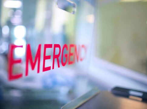 Red EMERGENCY sign on glass door.