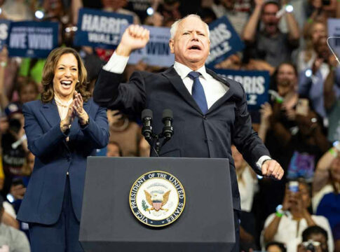Two people at a political rally on stage.