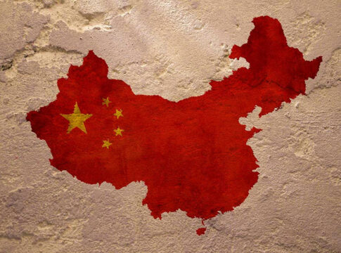 Chinas map with flag painted on textured wall.
