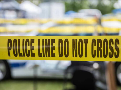 Yellow police tape that says, Police Line Do Not Cross.