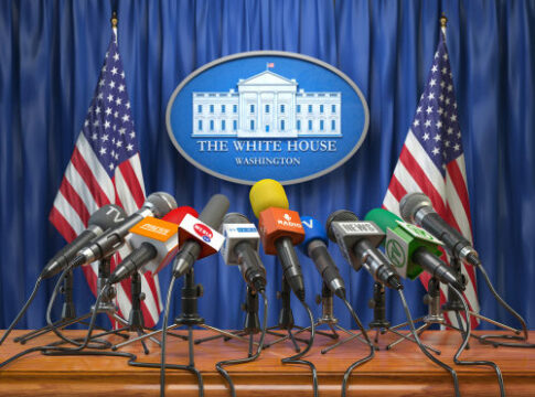 Press briefing podium with many microphones at a government venue