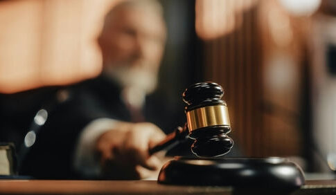 Judge's gavel striking sounding block in courtroom