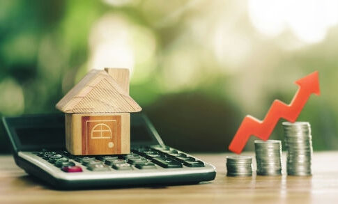 Toy house, calculator, coins, and red upward arrow.
