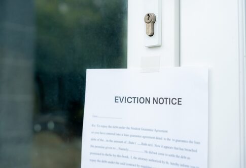 An eviction notice posted on a door with a keyhole visible